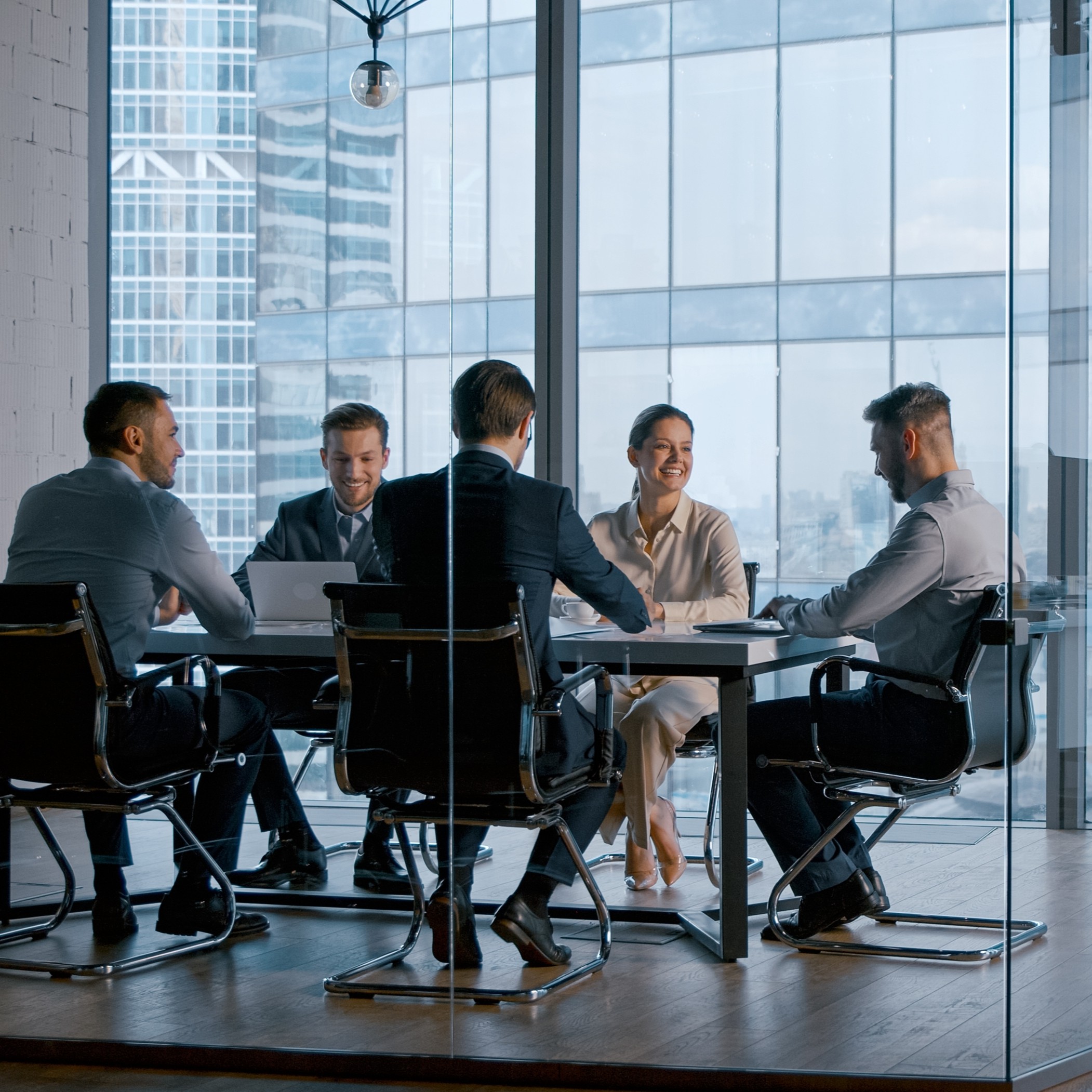 Odgers - A group of people sat around a table in a office